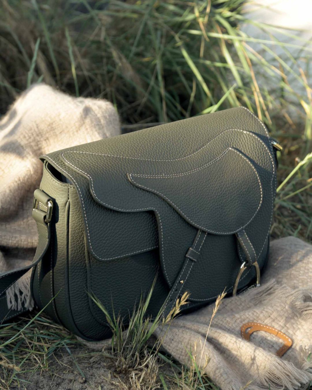 Notre sac Casaque en cuir façon vigogne kaki vu posé.