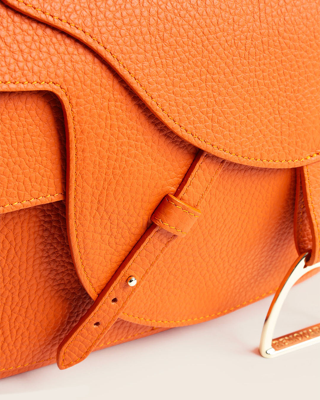 Notre sac Casaque en cuir façon vigogne orange vu de près en studio.