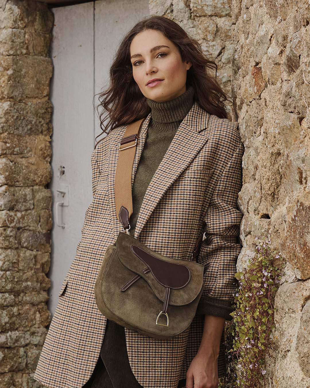Notre sac Cavalerie Renouard en cuir veau velours truffe avec sa bandoulière en coton, vu porté par notre mannequin.