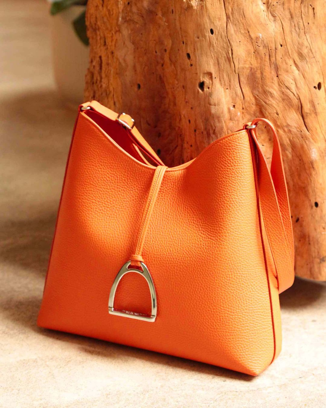 Our large Cob bag in orange vicuña-style leather, seen from the quarter.