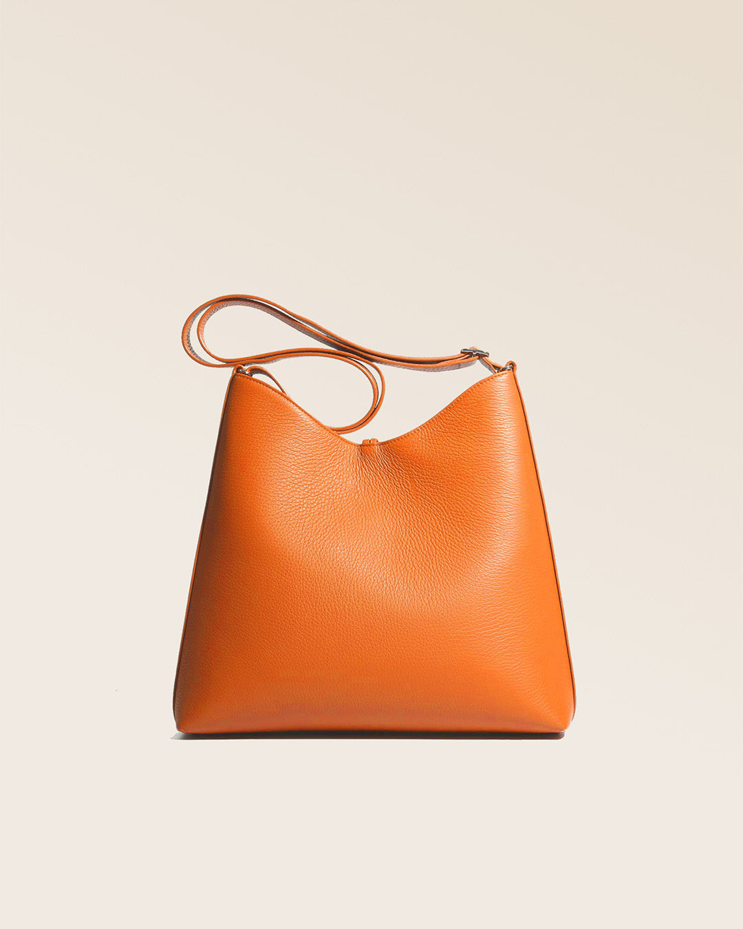 Our large Cob bag in orange vicuña-style leather, seen from the back in the studio.