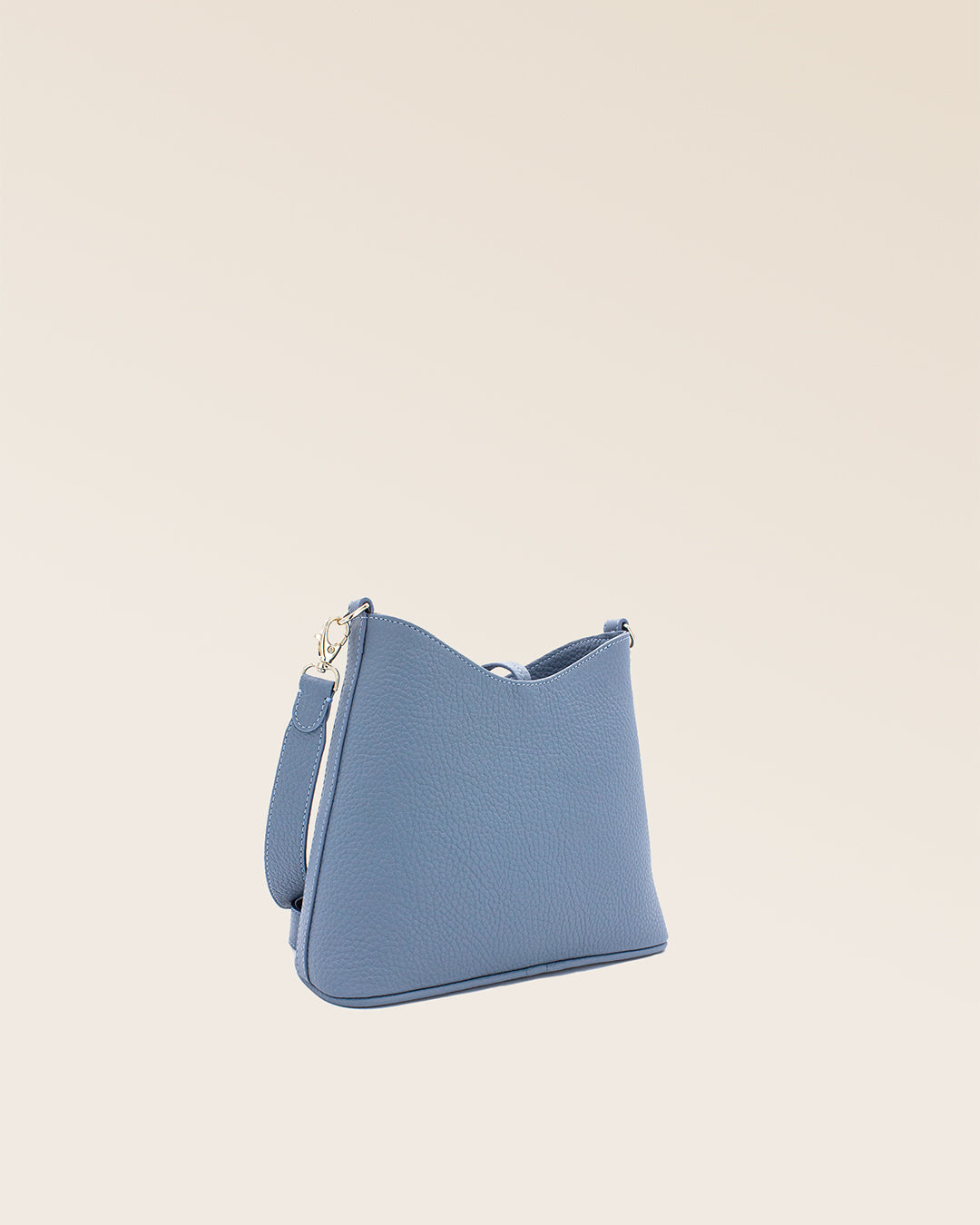 Notre sac Mini Cob en cuir façon vigogne bleu cobalt et bandoulière cuir, vu de dos en studio.