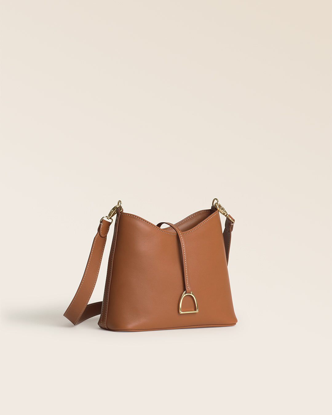 Notre sac Cob Renouard dans sa version Mini modèle, en cuir vintage camel et bandoulière cuir ; vu de quart en studio.