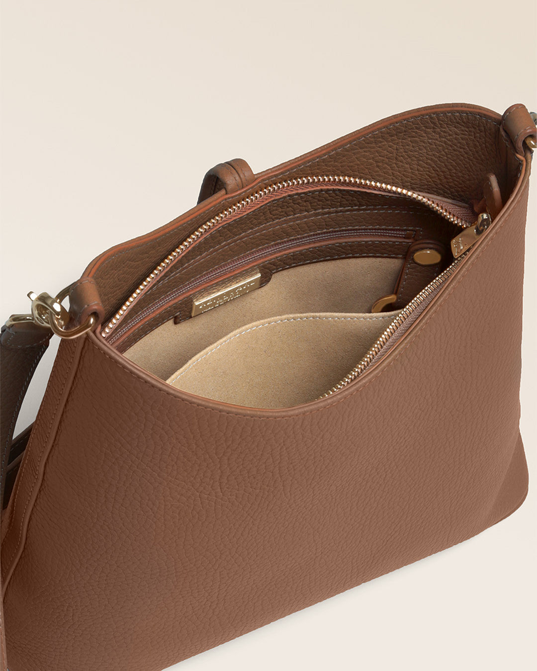 Notre sac Cob Renouard dans sa version Petit modèle, cuir façon vigogne fauve et bandoulière cuir ; vu ouvert en studio.