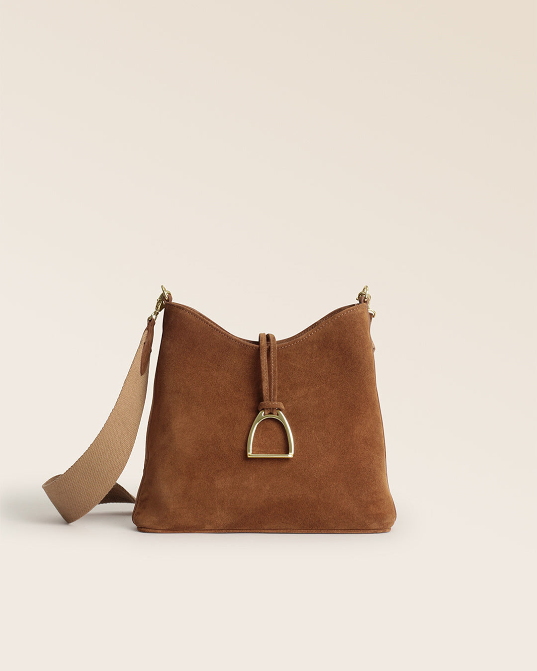 Notre sac Cob Renouard dans sa version petit modèle, cuir veau velours noisette et bandoulière coton camel ; vu de face en studio.