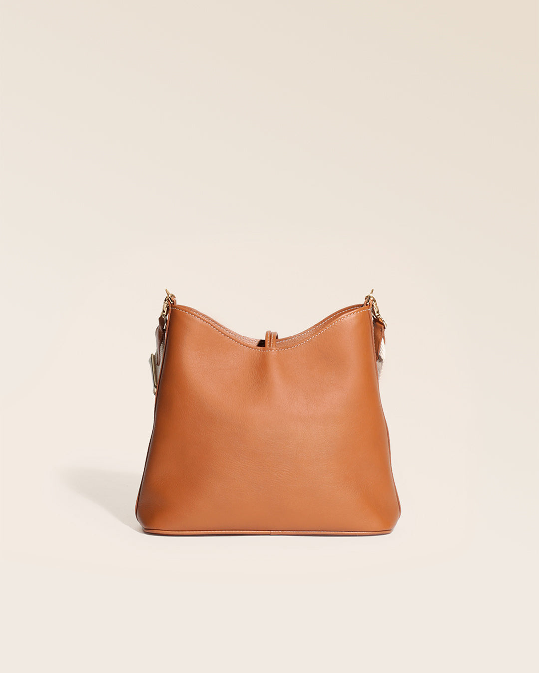 Notre sac Cob Renouard dans sa version petit modèle, cuir vintage camel et bandoulière coton, vu de dos en studio.