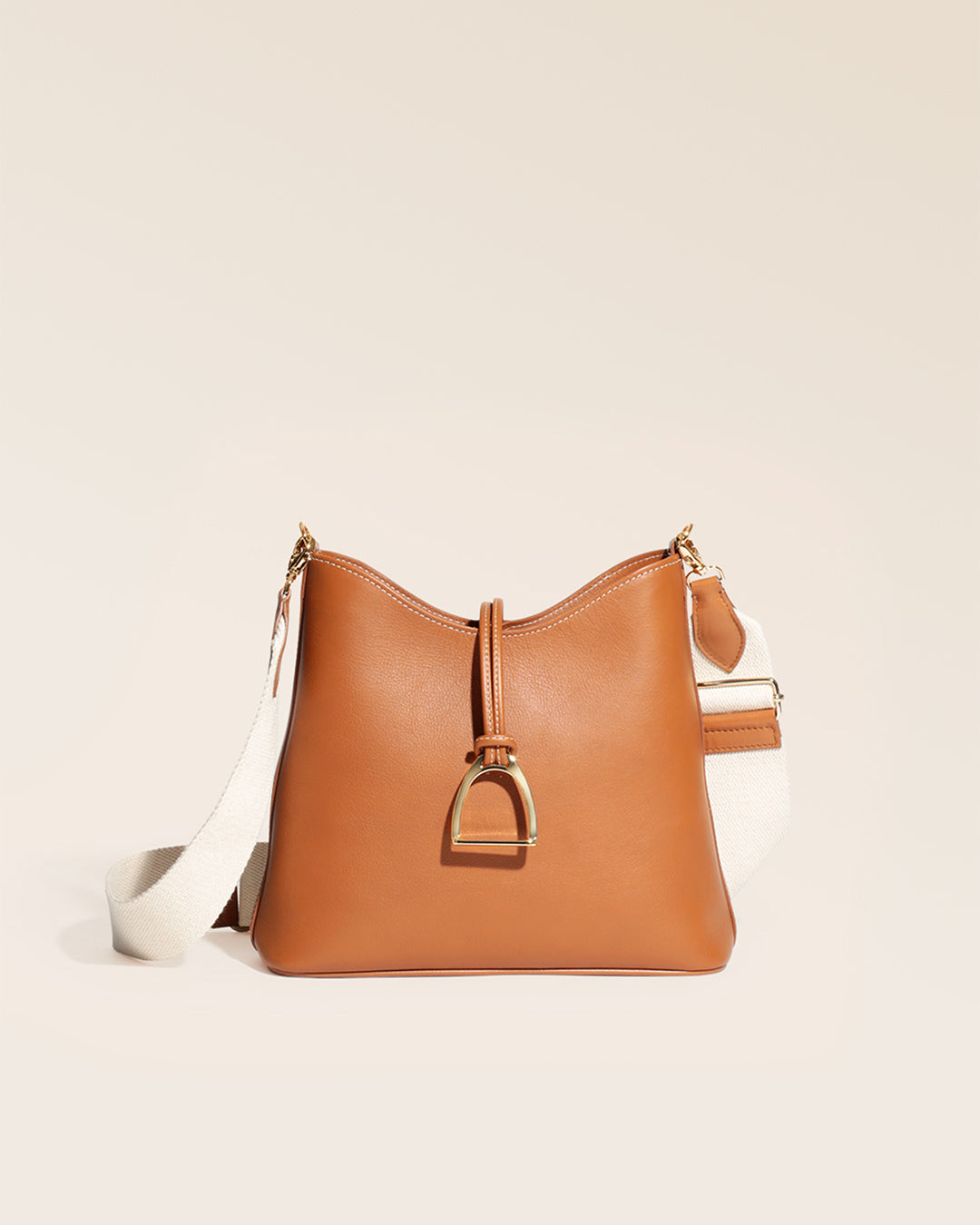 Notre sac Cob Renouard dans sa version petit modèle, cuir vintage camel et bandoulière coton, vu de face en studio.