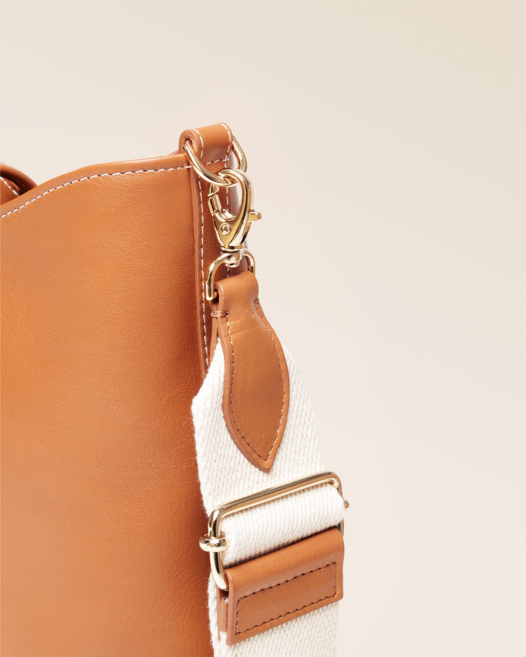 Notre sac Cob Renouard dans sa version petit modèle, cuir vintage camel et bandoulière coton, vu de près en studio.