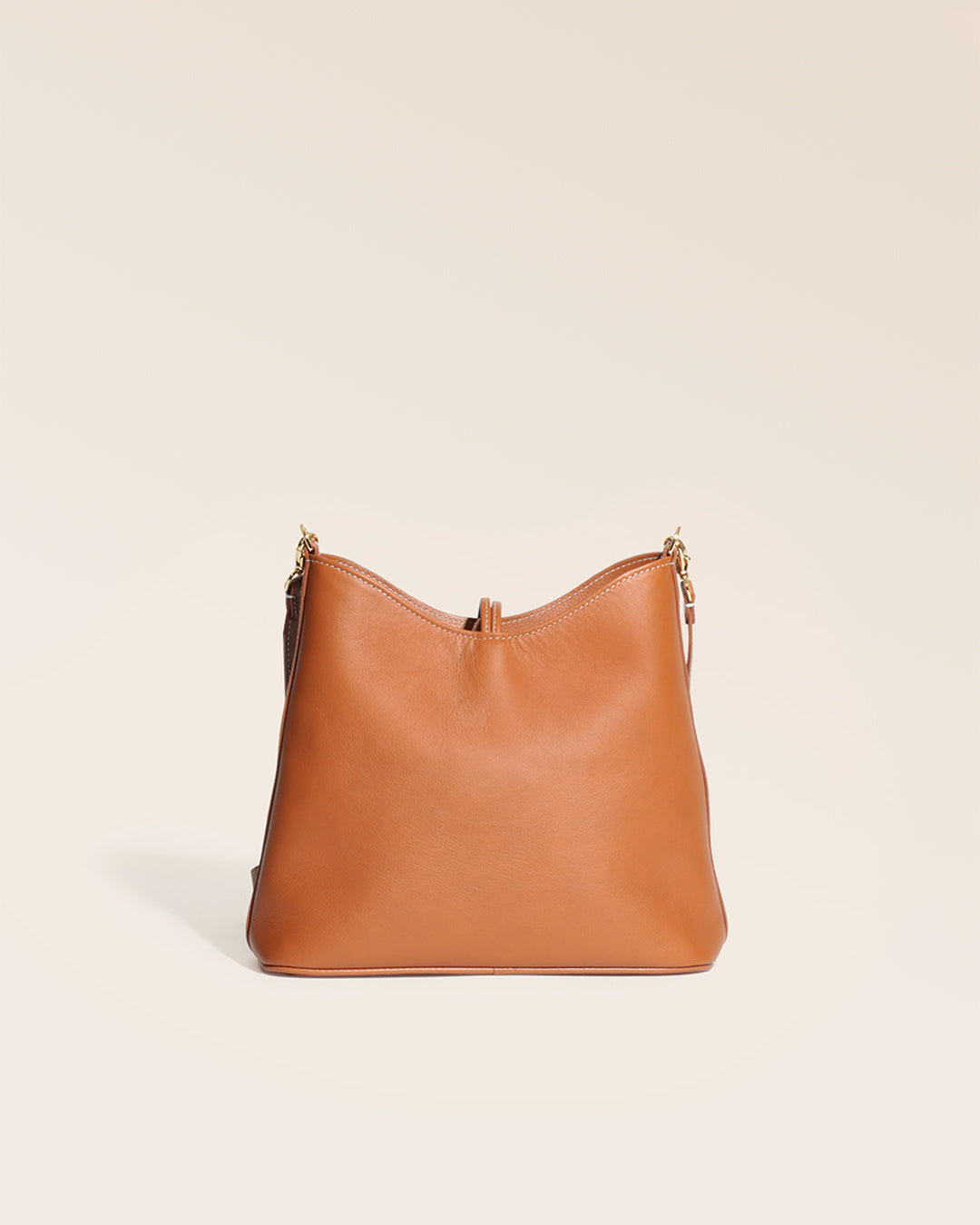 Notre sac Cob Renouard dans sa version petit modèle, cuir vintage camel et bandoulière cuir, vu de dos en studio.