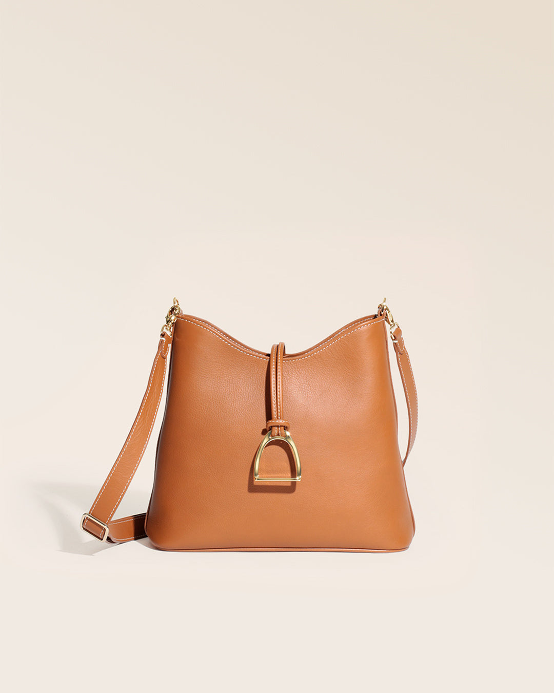 Notre sac Cob Renouard dans sa version petit modèle, cuir vintage camel et bandoulière cuir, vu de face en studio.