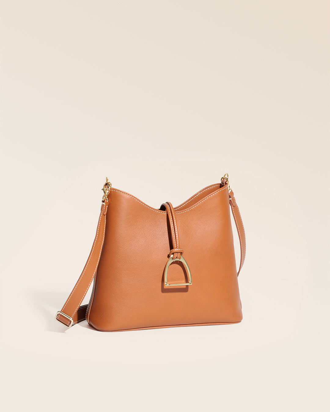 Notre sac Cob Renouard dans sa version petit modèle, cuir vintage camel et bandoulière cuir, vu de quart en studio.