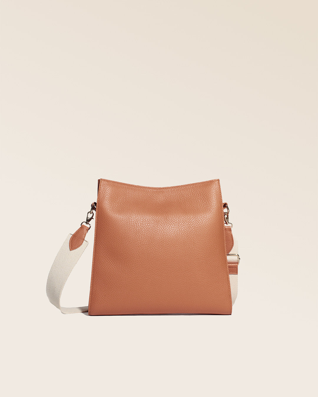Notre sac Étrivière petit modèle en cuir façon vigogne fauve et bandoulière coton vu de dos en studio.