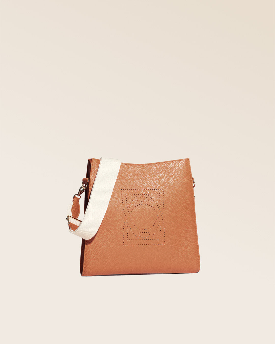 Notre sac Étrivière petit modèle en cuir façon vigogne fauve et bandoulière coton vu de quart en studio.
