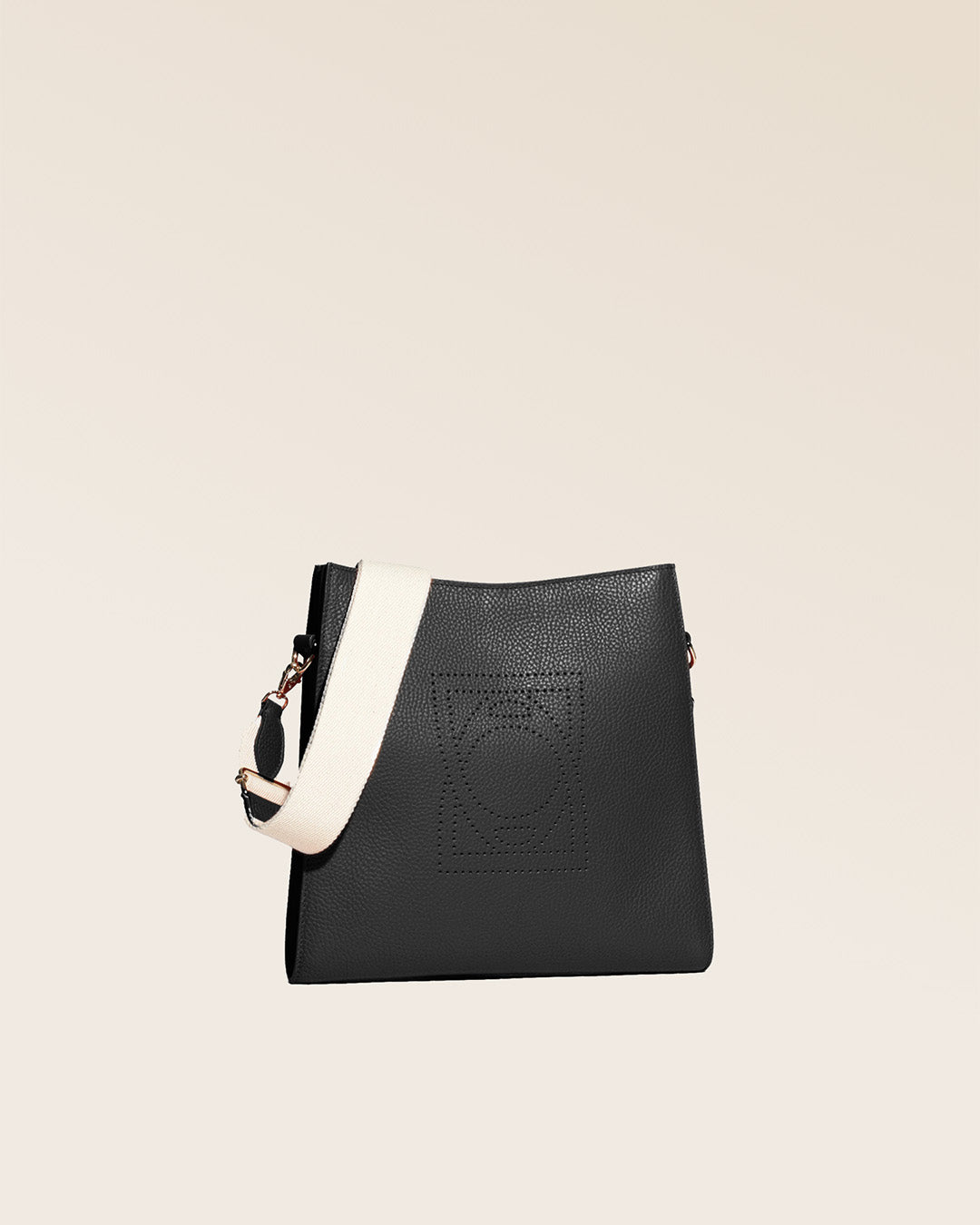 Notre sac Étrivière petit modèle en cuir façon vigogne noir et bandoulière coton vu de quart en studio.