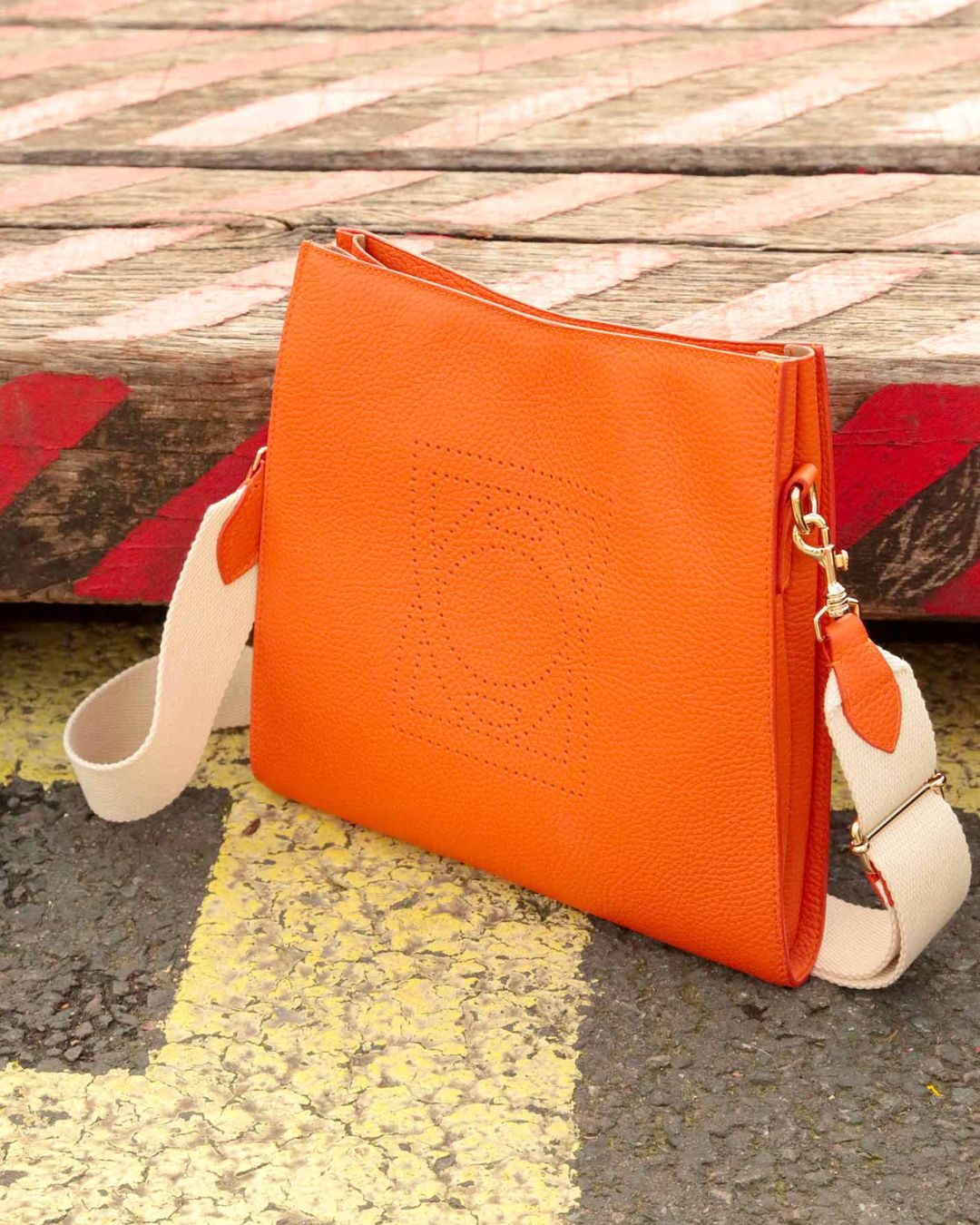 Our Étrivière small bag in orange vicuña-style leather, seen from the front.