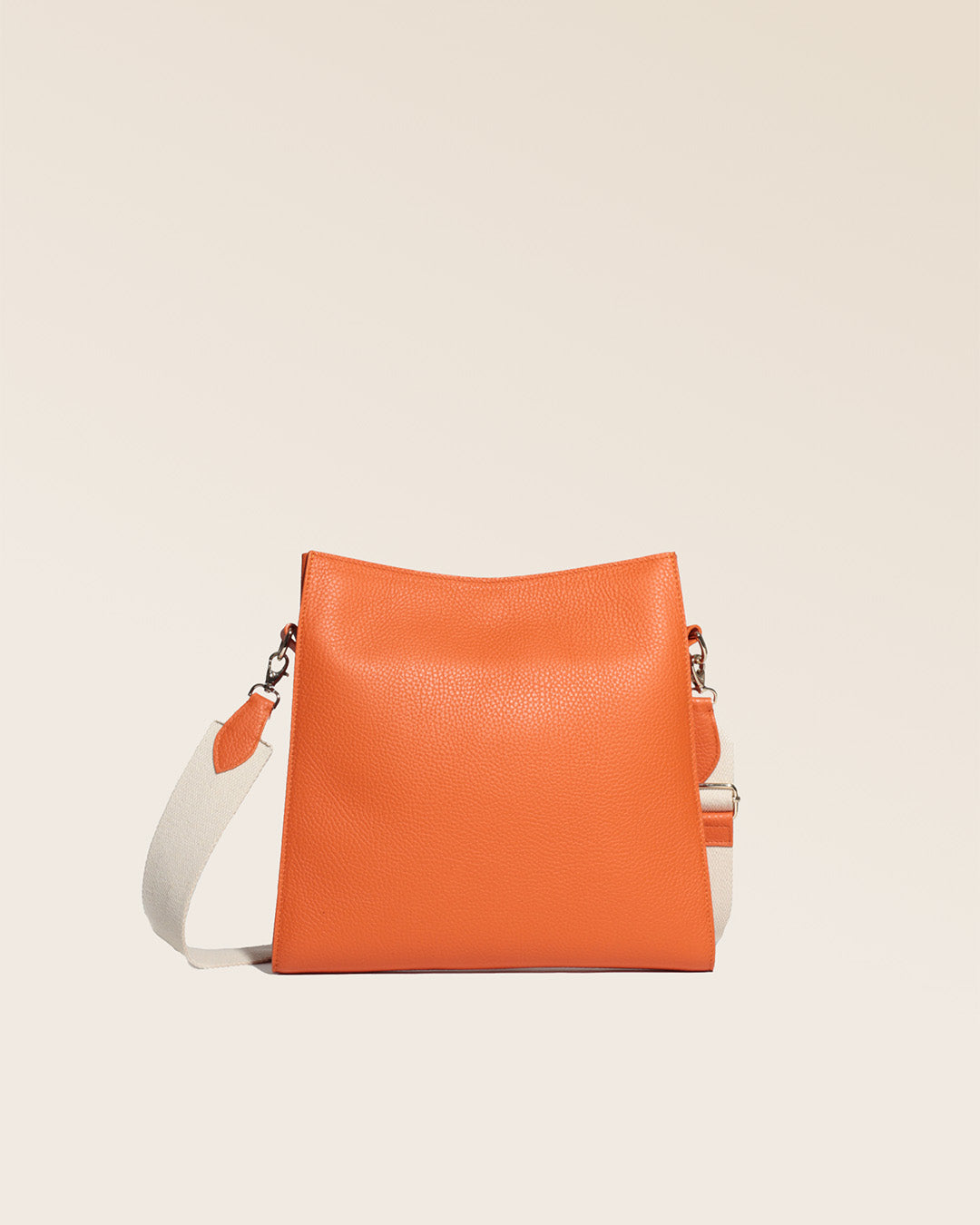 Our Étrivière small bag in orange vicuña-style leather, seen from the back in the studio.