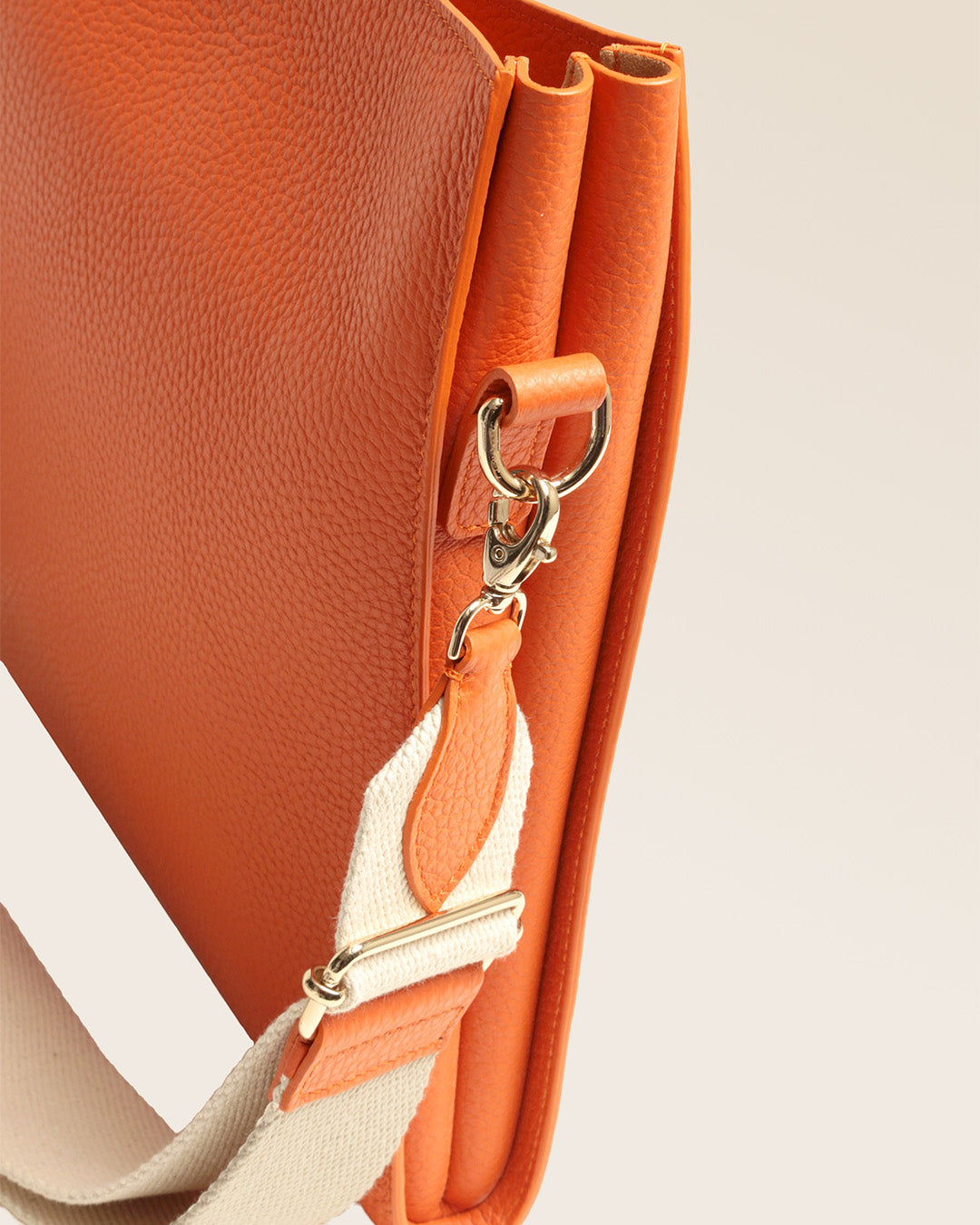 Our Étrivière small bag in orange vicuña-style leather seen in detail in the studio.