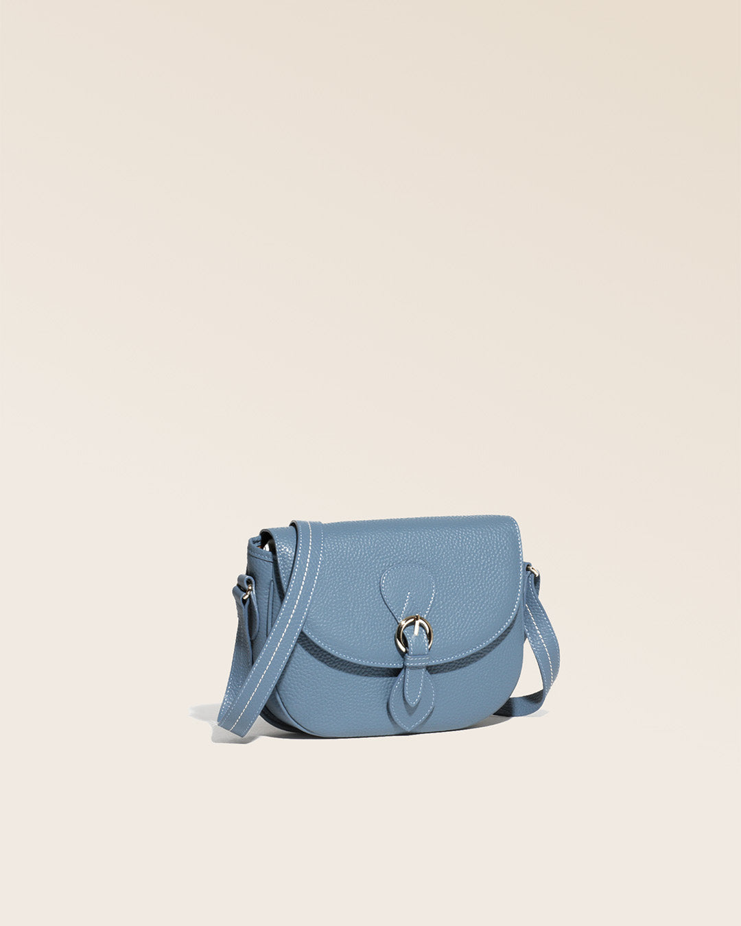 Notre sac gibecière Léa en cuir façon vigogne bleu cobalt vu de quart en studio.