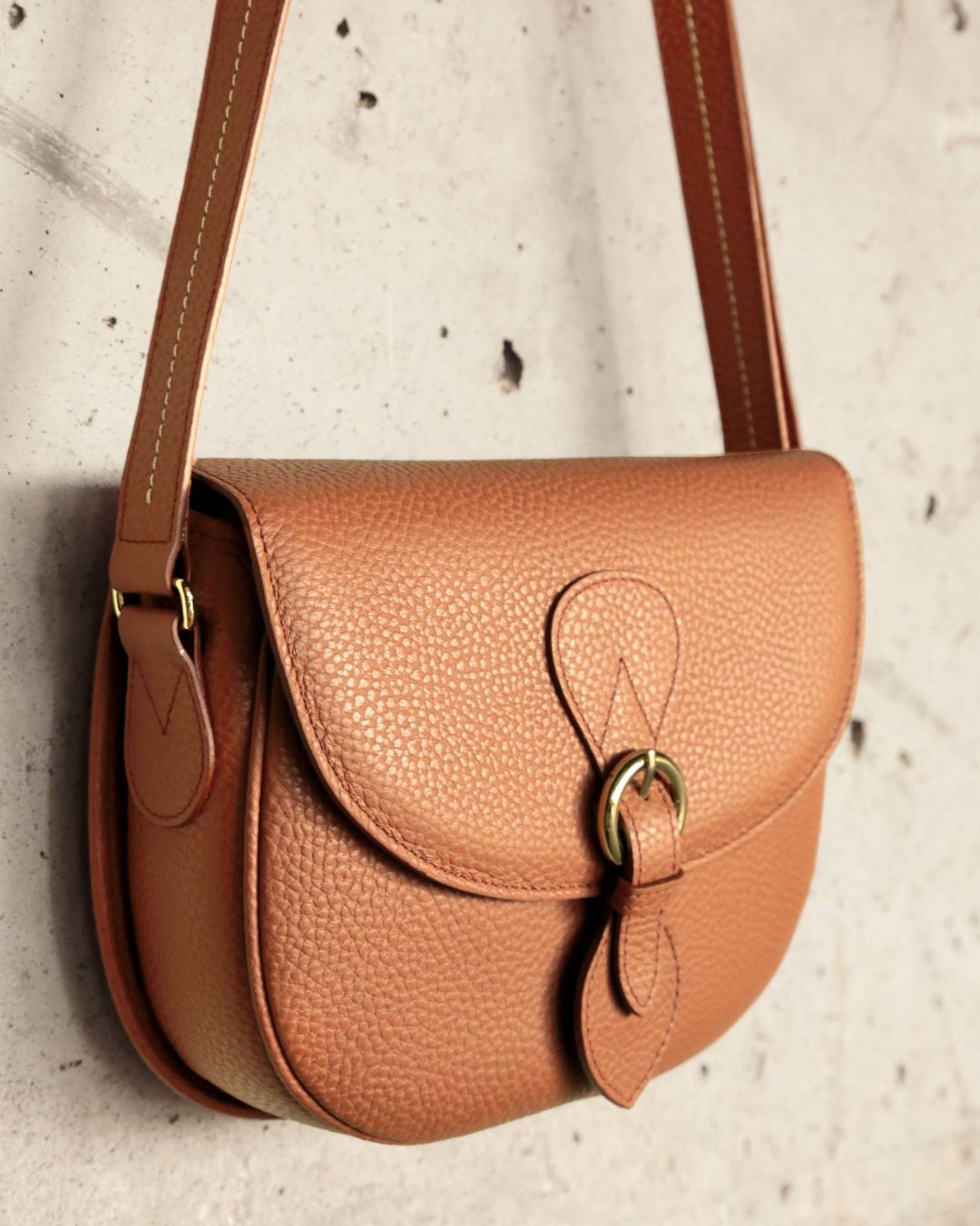 Notre sac gibecière Léa en cuir façon vigogne fauve vu de près en ambiance.