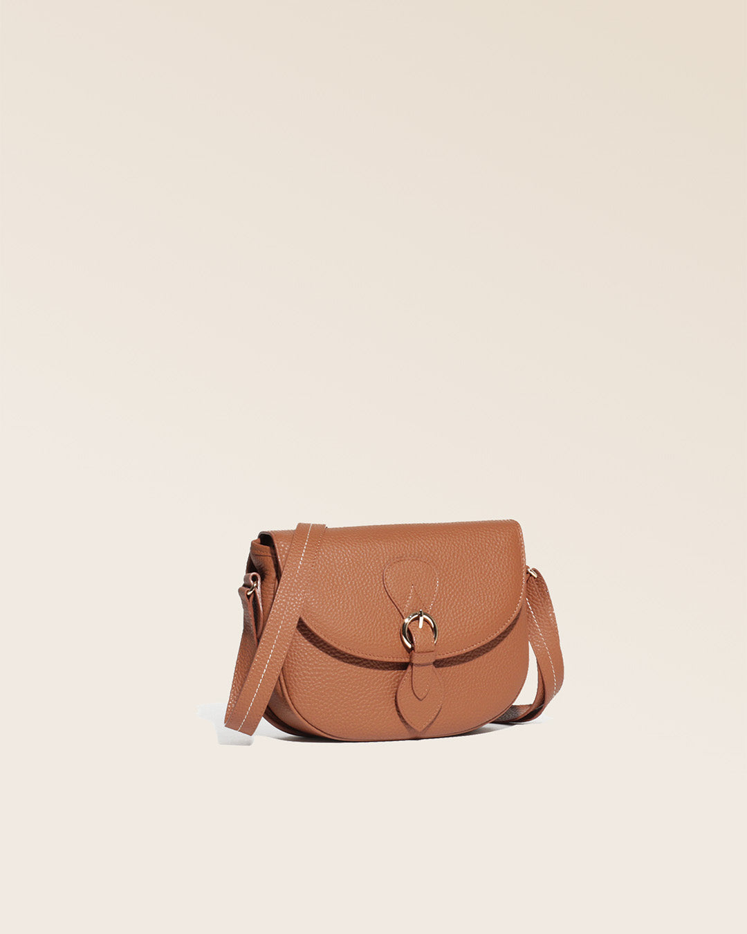 Notre sac gibecière Léa en cuir façon vigogne fauve vu de quart en studio.