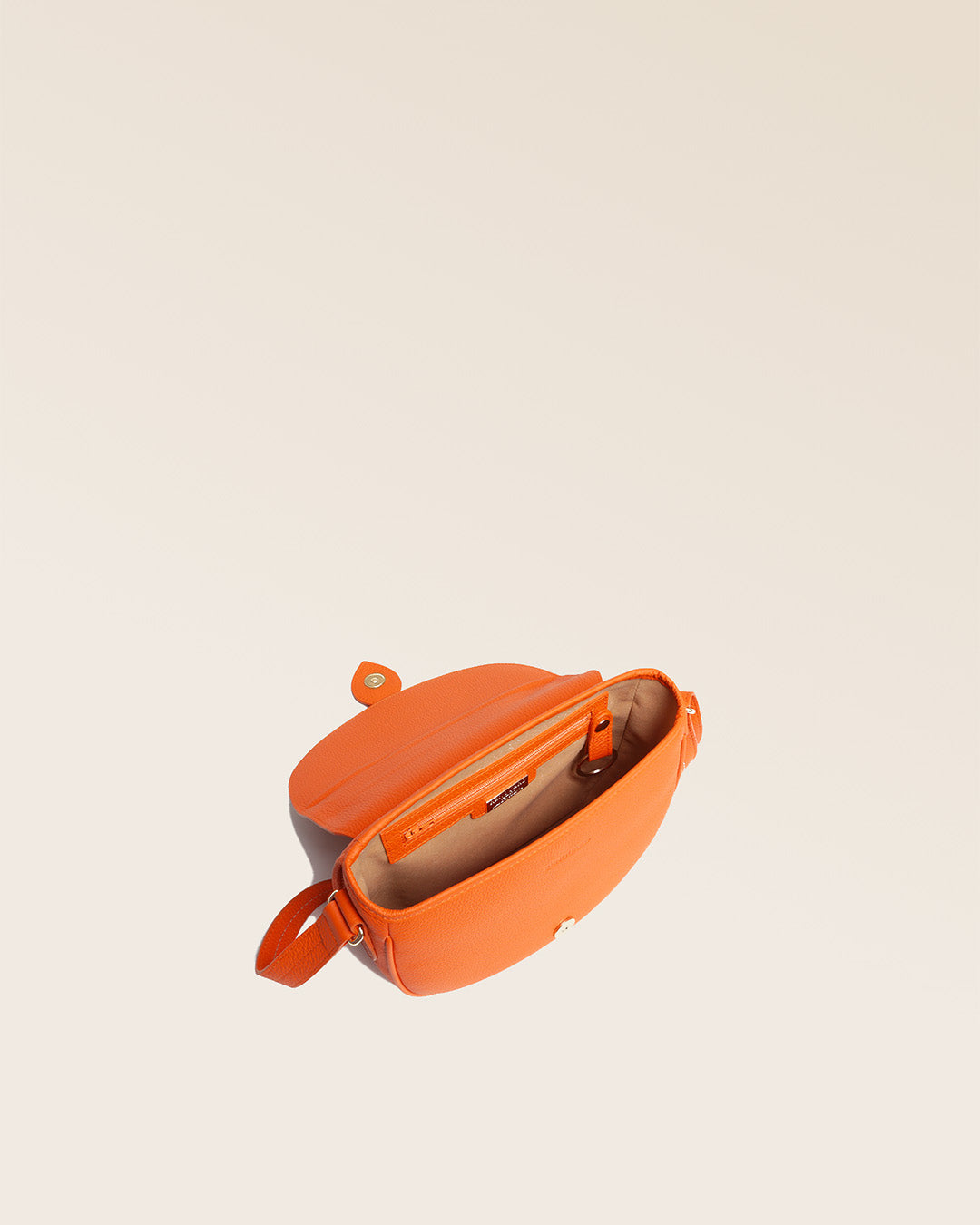 Notre sac gibecière Léa en cuir façon vigogne orange vu de quart en studio.
