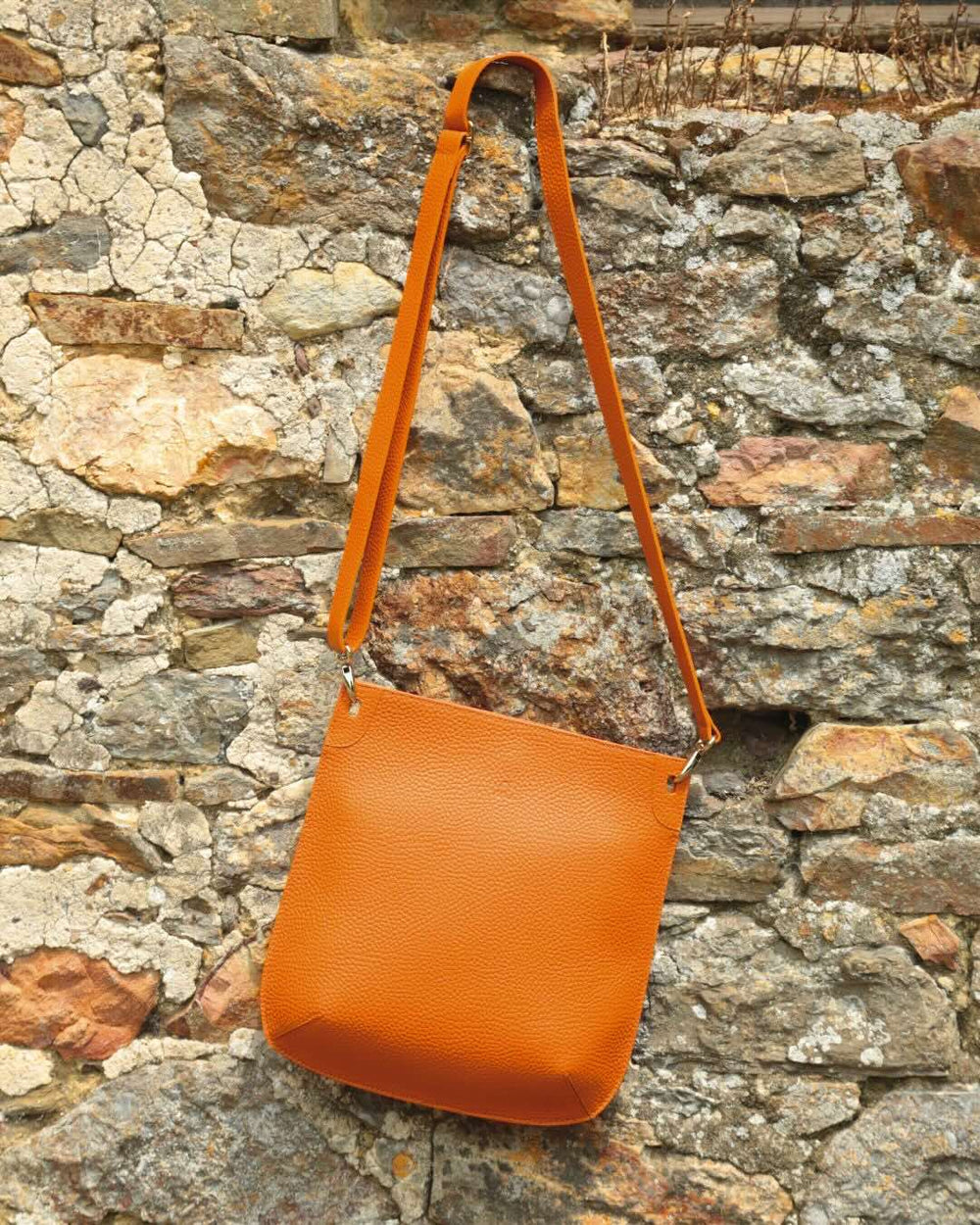 Notre sac Harnais en cuir façon vigogne orange vu de face en ambiance.