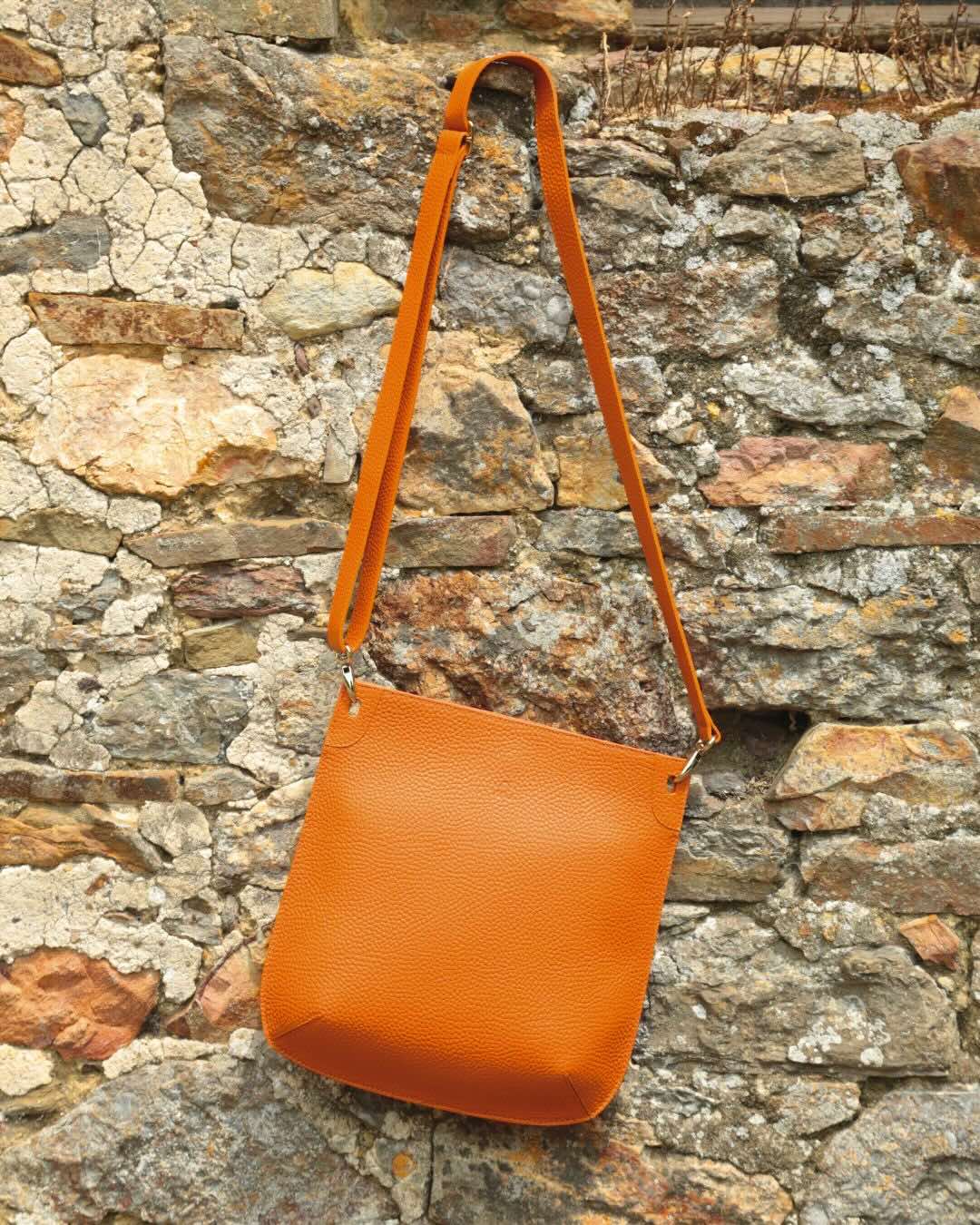 Notre sac Harnais en cuir façon vigogne orange vu de face en ambiance.