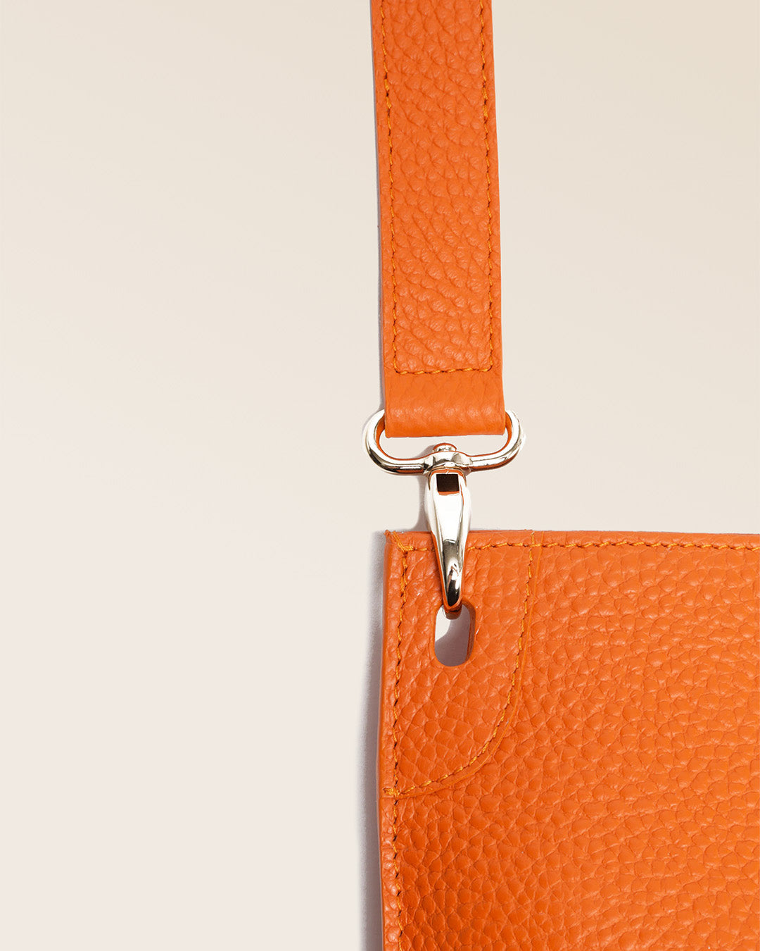 Notre sac Harnais en cuir façon vigogne orange vu de près en studio.