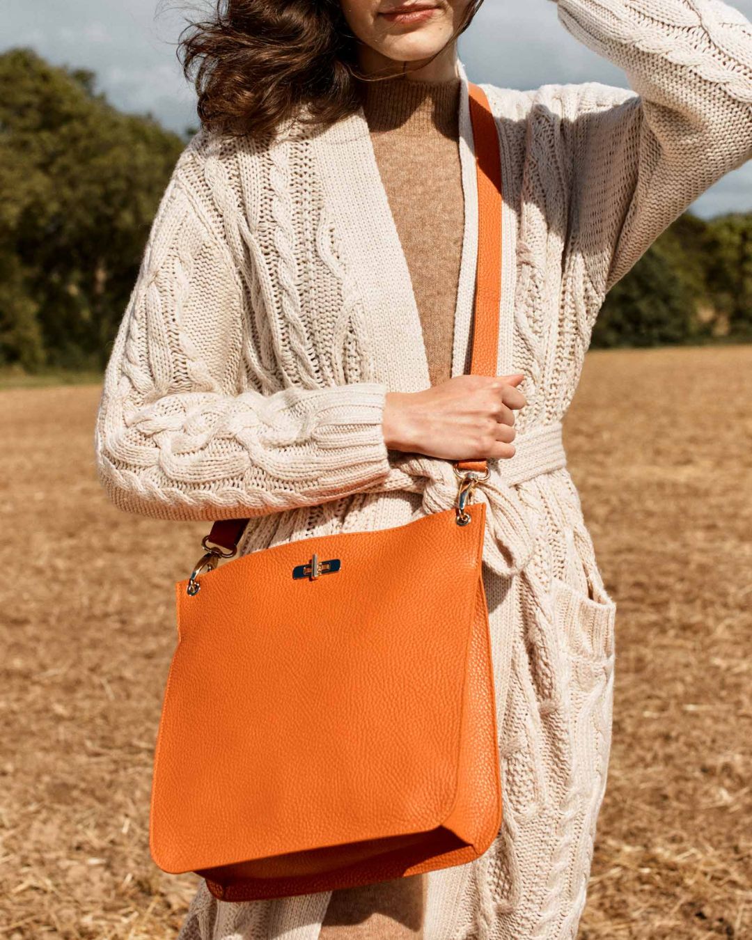 Our Hermine bag in orange vicuña-style leather as seen on our model Léa.