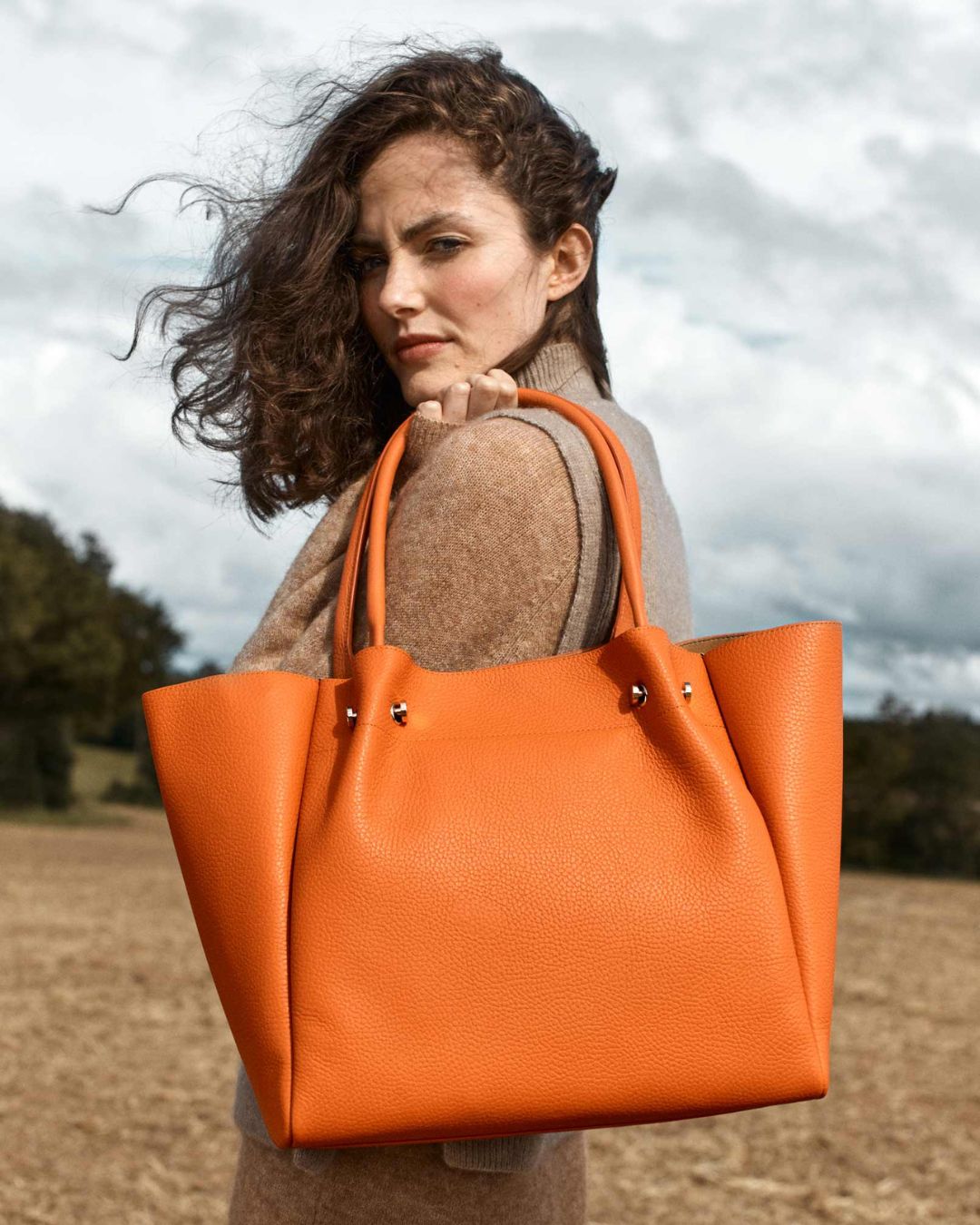 Notre sac Josepha en cuir façon vigogne orange vu porté par notre mannequin Léa Gouaux.