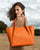 Notre sac Josepha en cuir façon vigogne orange vu porté par notre mannequin Léa Gouaux.