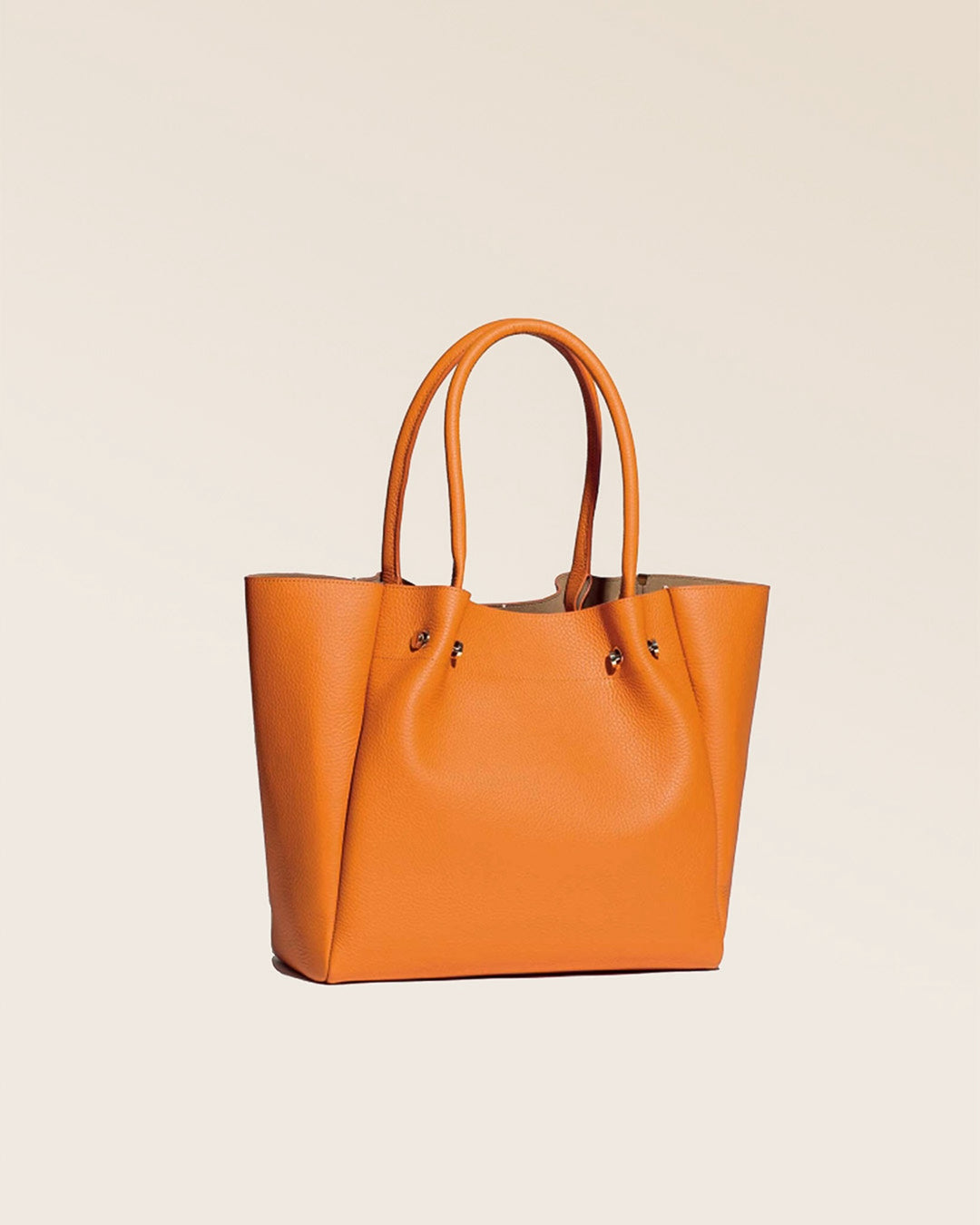Notre sac Josepha en cuir façon vigogne orange vu de quart en studio.