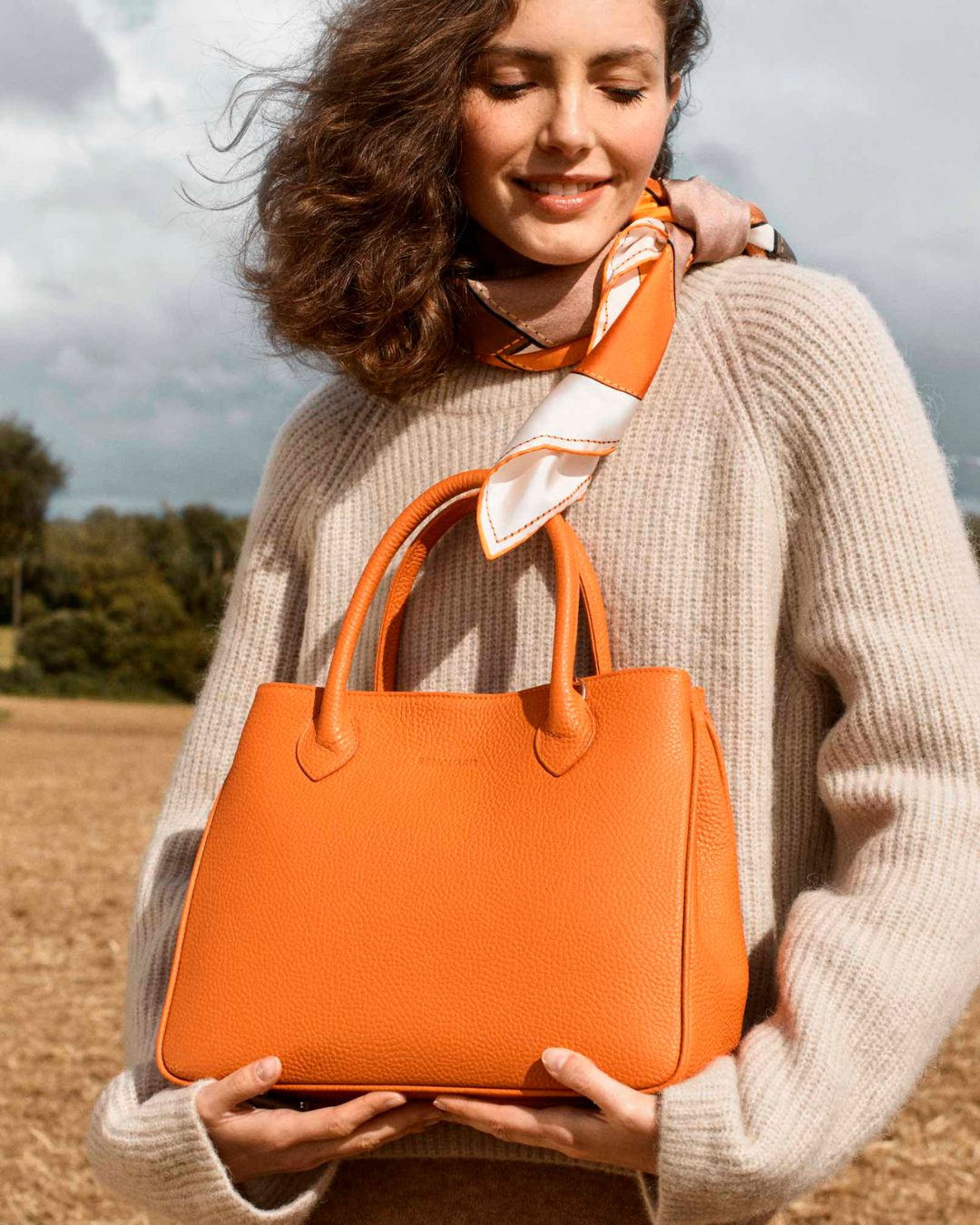 Our Ker Balmoral bag in orange vicuña-style leather as seen on model Léa Gouaux.