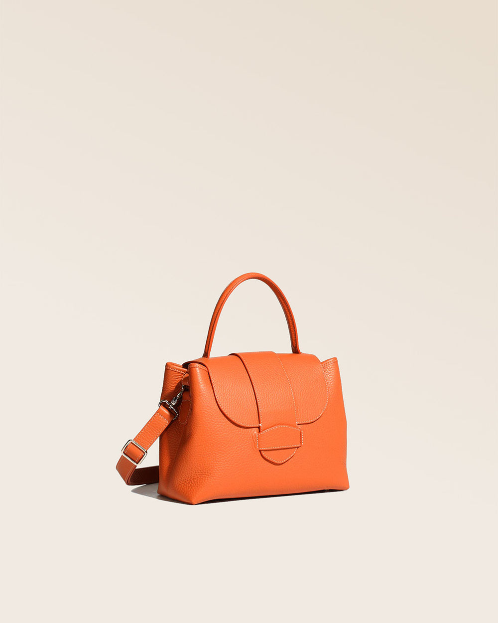 Notre sac Kimono en cuir façon vigogne orange vu de quart en studio.