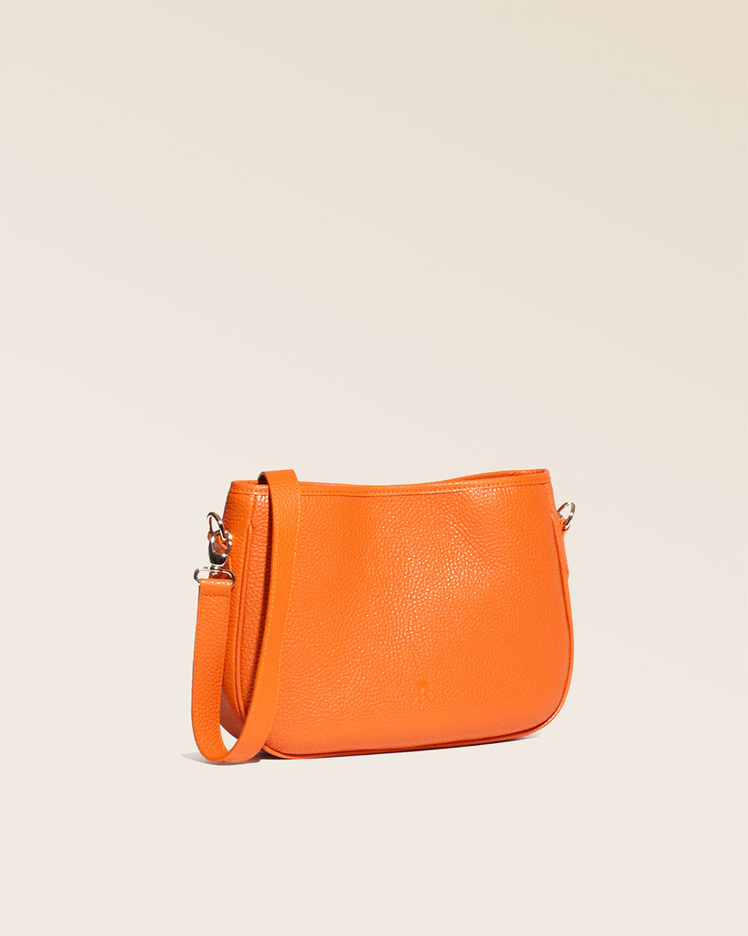 Notre sac Léonore en cuir façon vigogne orange vu de quart en studio.