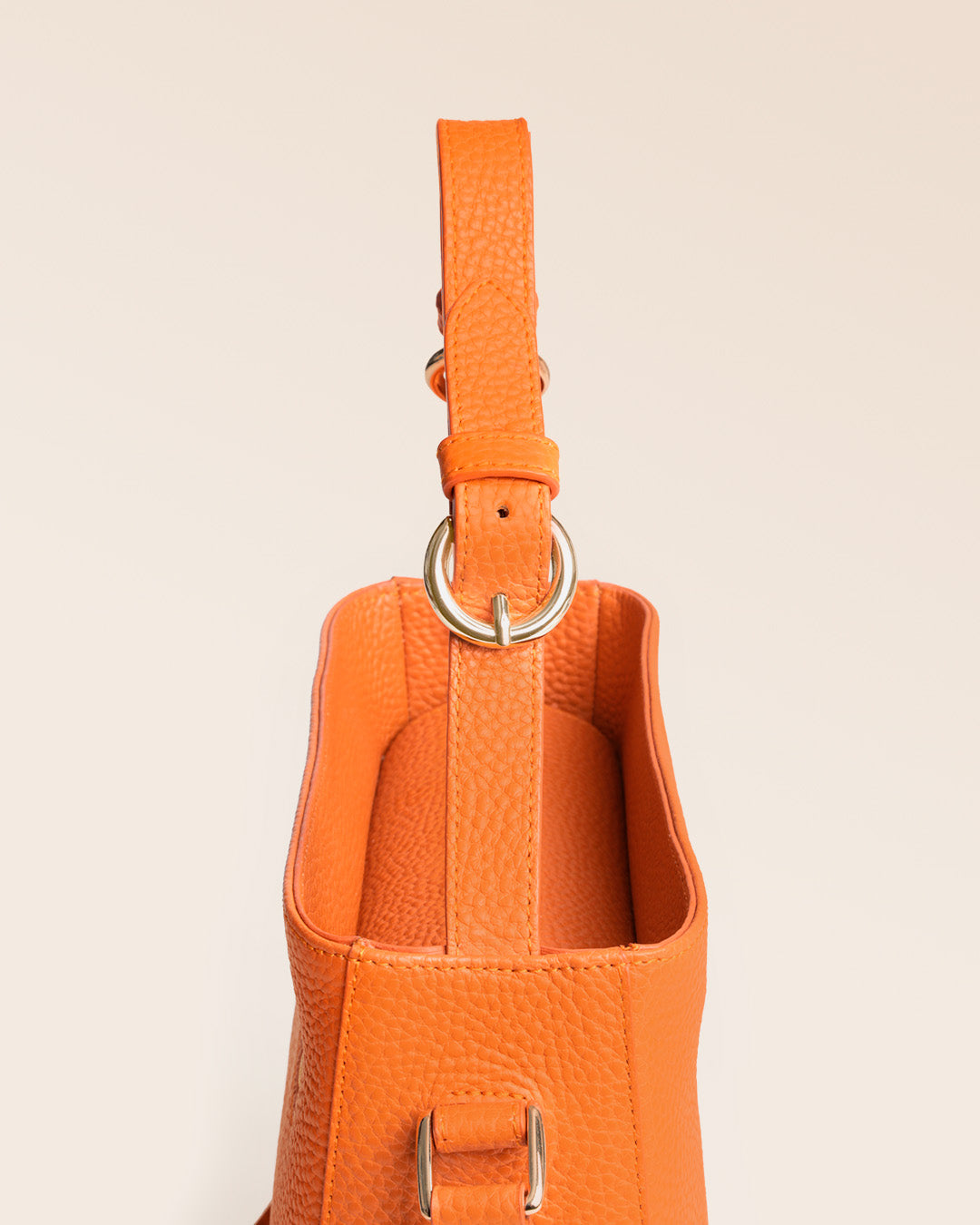 Notre sac Marlow en cuir façon vigogne orange vu en détail en studio.