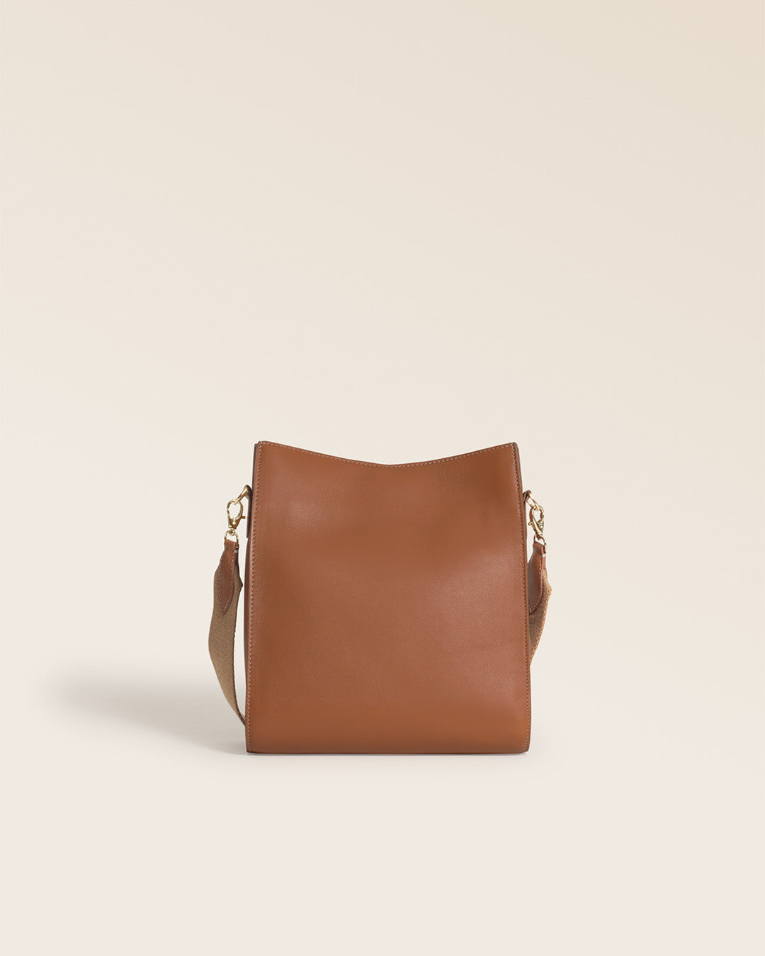 Notre sac Mini Étrivière Renouard en cuir vintage camel et bandoulière coton camel, vu de dos en studio.