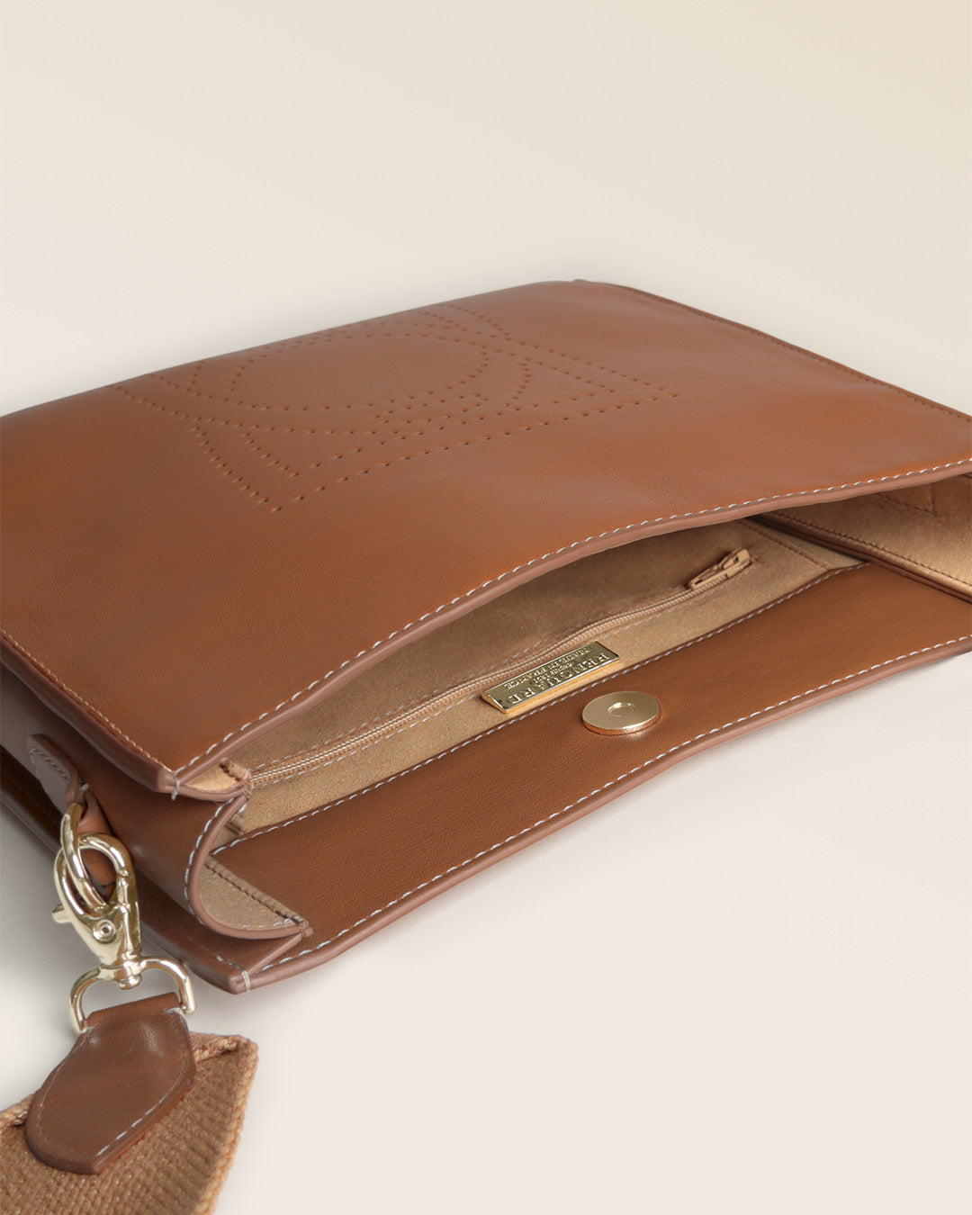Notre sac Mini Étrivière Renouard en cuir vintage camel et bandoulière coton camel, vu de l'intérieur en studio.