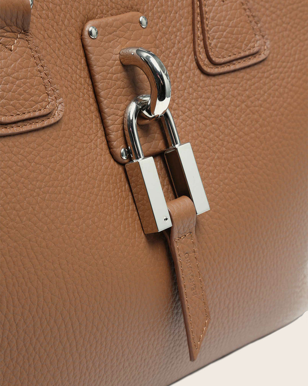 Notre sac New-York petit modèle en cuir façon vigogne fauve vu en détails en studio.