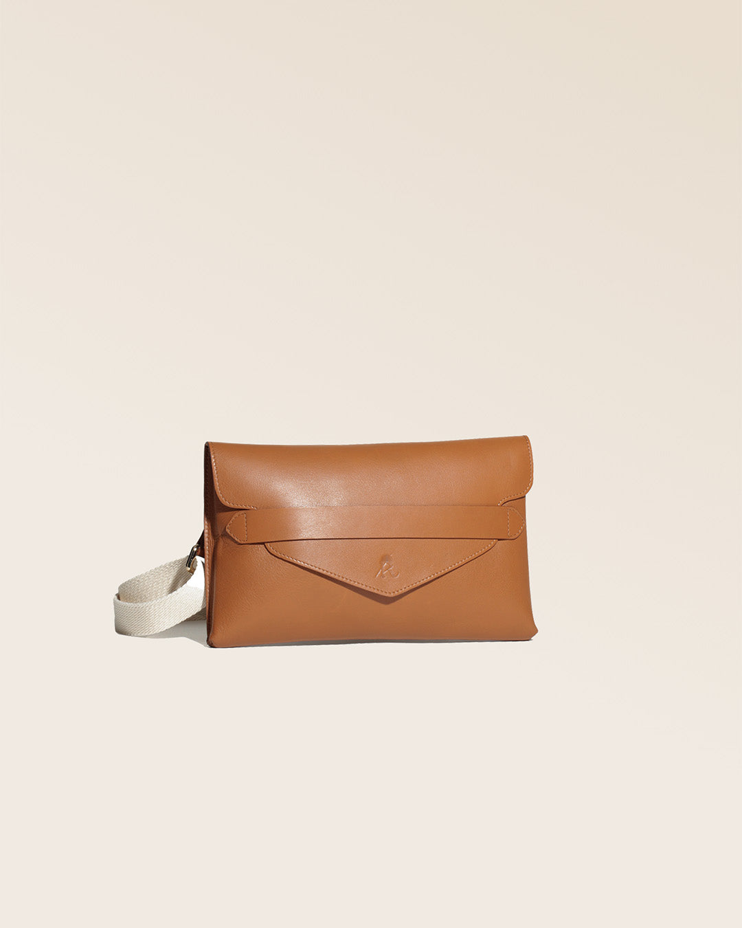 Notre pochette Clipper en cuir vintage camel vu de quart en studio.