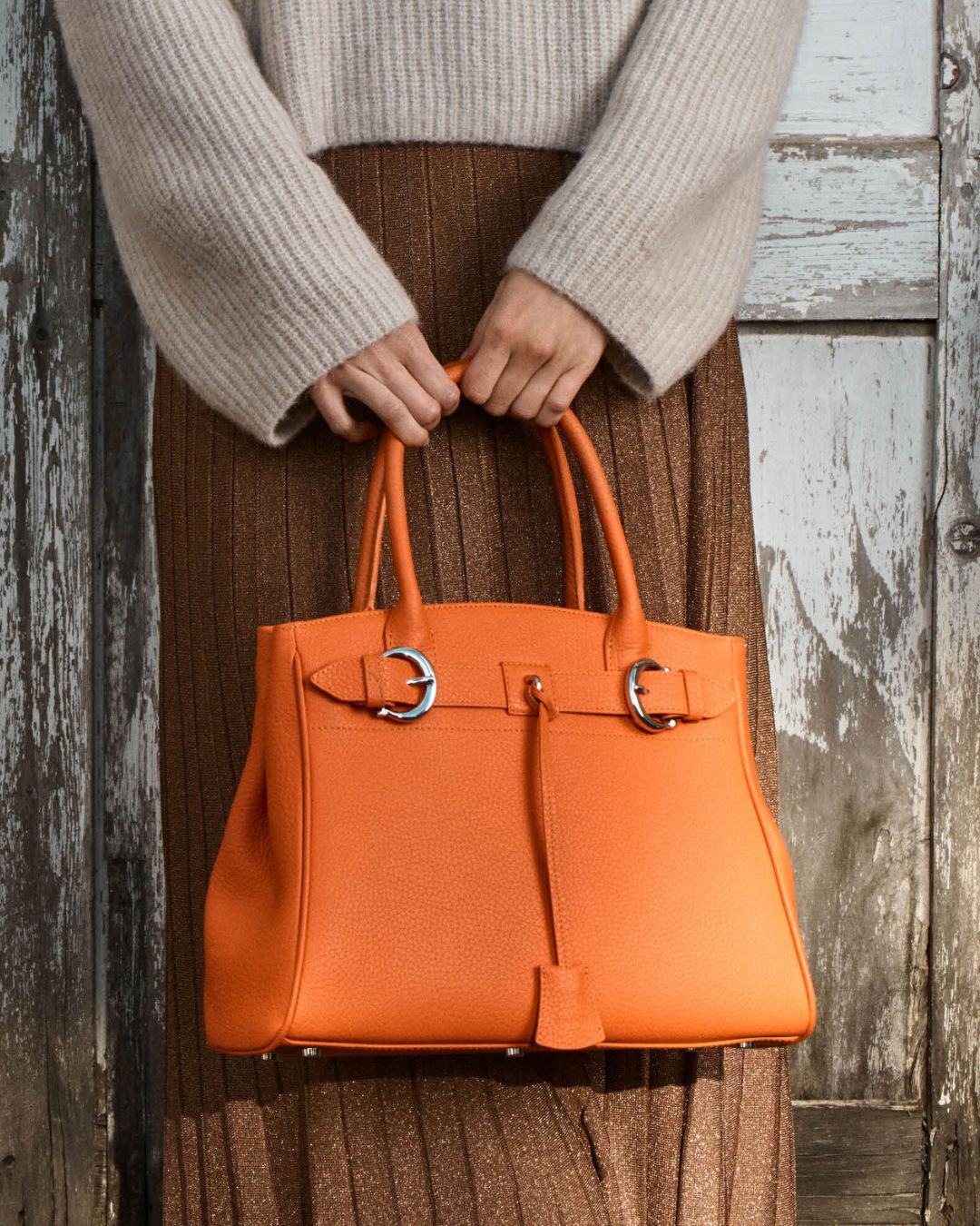 Notre sac Prestige Renouard, dans sa version Mini, en cuir façon vigogne orange , vu porté par notre mannequin.
