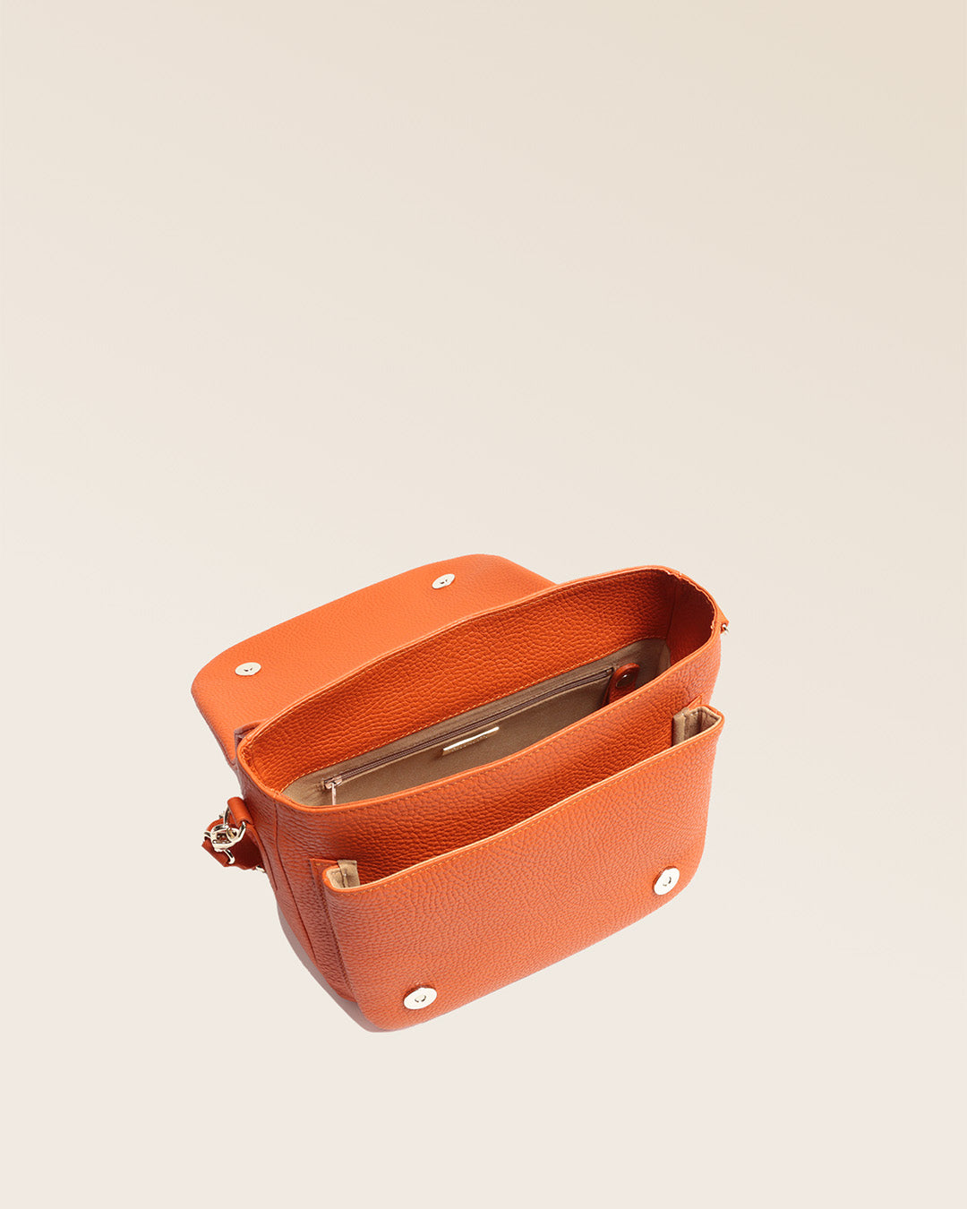Our Samuel bag in orange vicuña-style leather, seen from above in the studio.