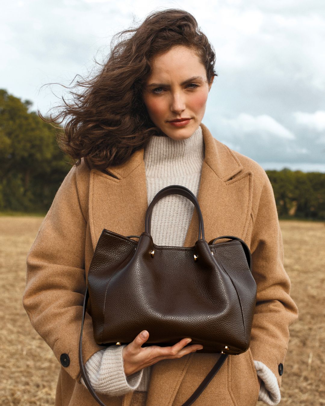 Notre sac Saturne en cuir façon vigogne chocolat vu de face porté par notre mannequin Léa Gouaux.