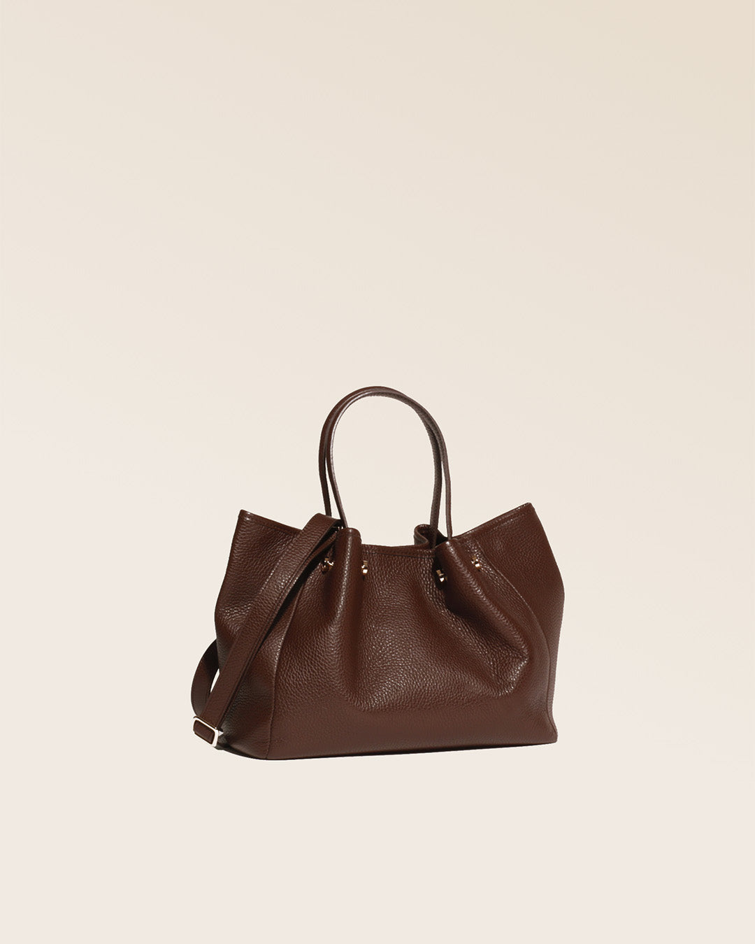 Notre sac Saturne en cuir façon vigogne orange vu de quart en studio.