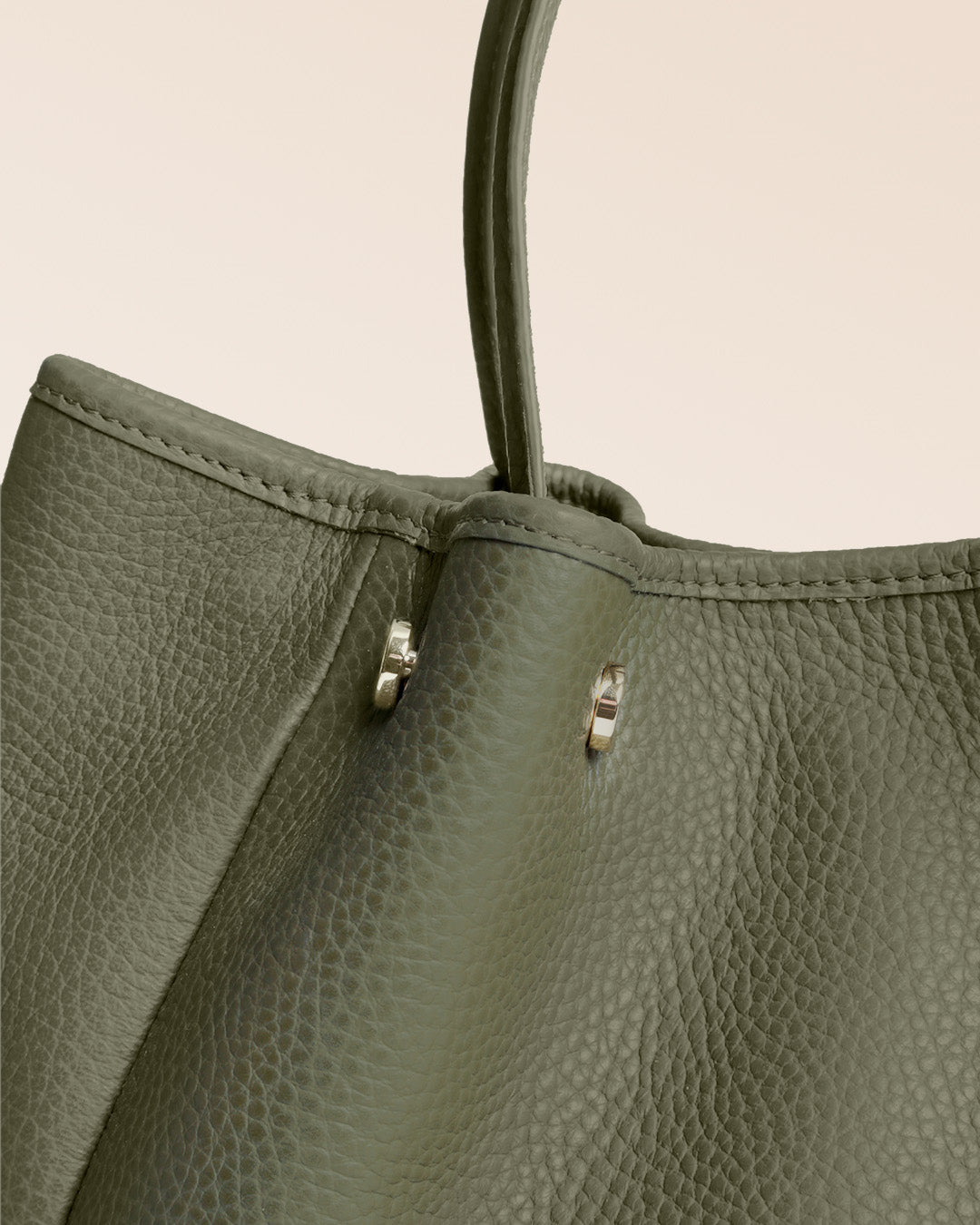 Notre sac Saturne en cuir façon vigogne kaki vu en détail en studio.