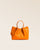 Notre sac Saturne en cuir façon vigogne orange vu de face en studio.