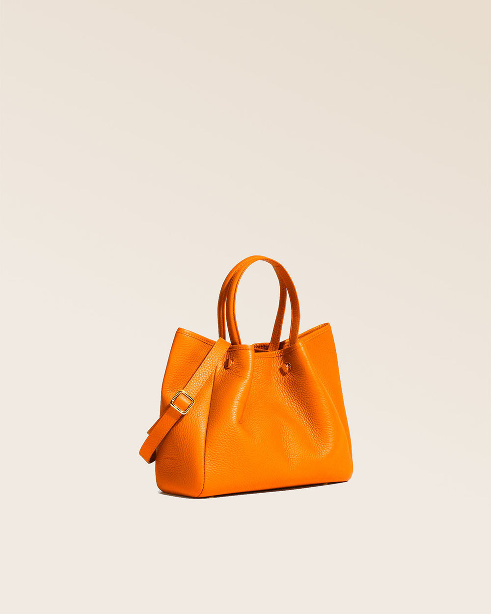 Notre sac Saturne en cuir façon vigogne orange vu de quart en studio.