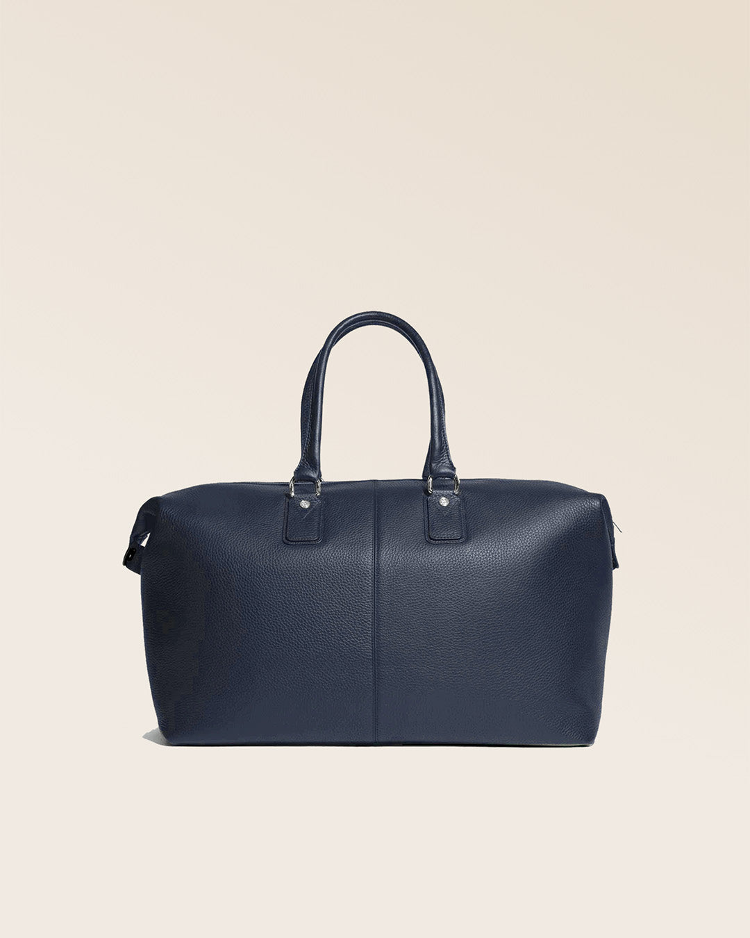 Notre sac de voyage Escapade grand modèle en cuir façon vigogne bleu marine vu de dos en studio.