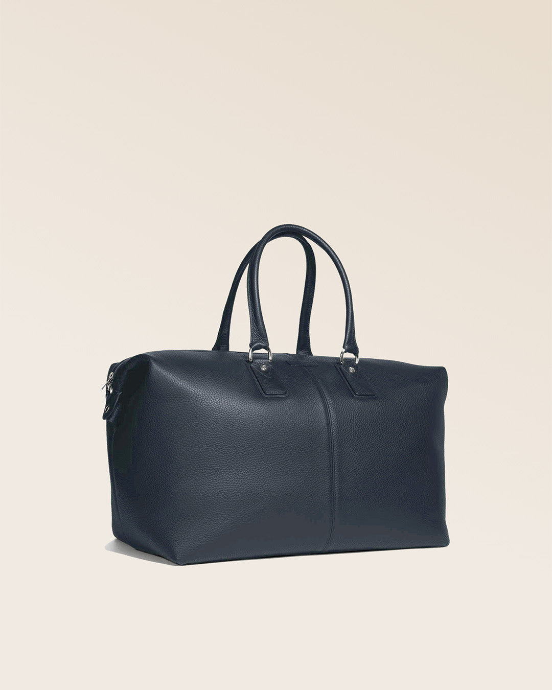 Notre sac de voyage Escapade grand modèle en cuir façon vigogne bleu marine vu de quart en studio. #taille_grand