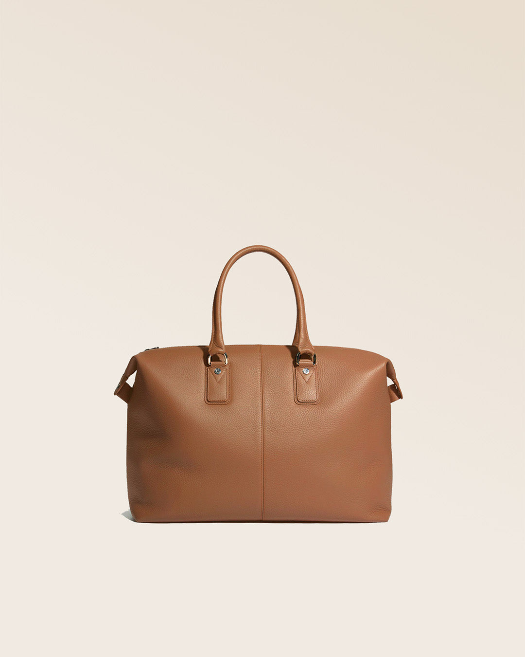 Notre sac de voyage Escapade petit modèle en cuir façon vigogne fauve vu de dos en studio.